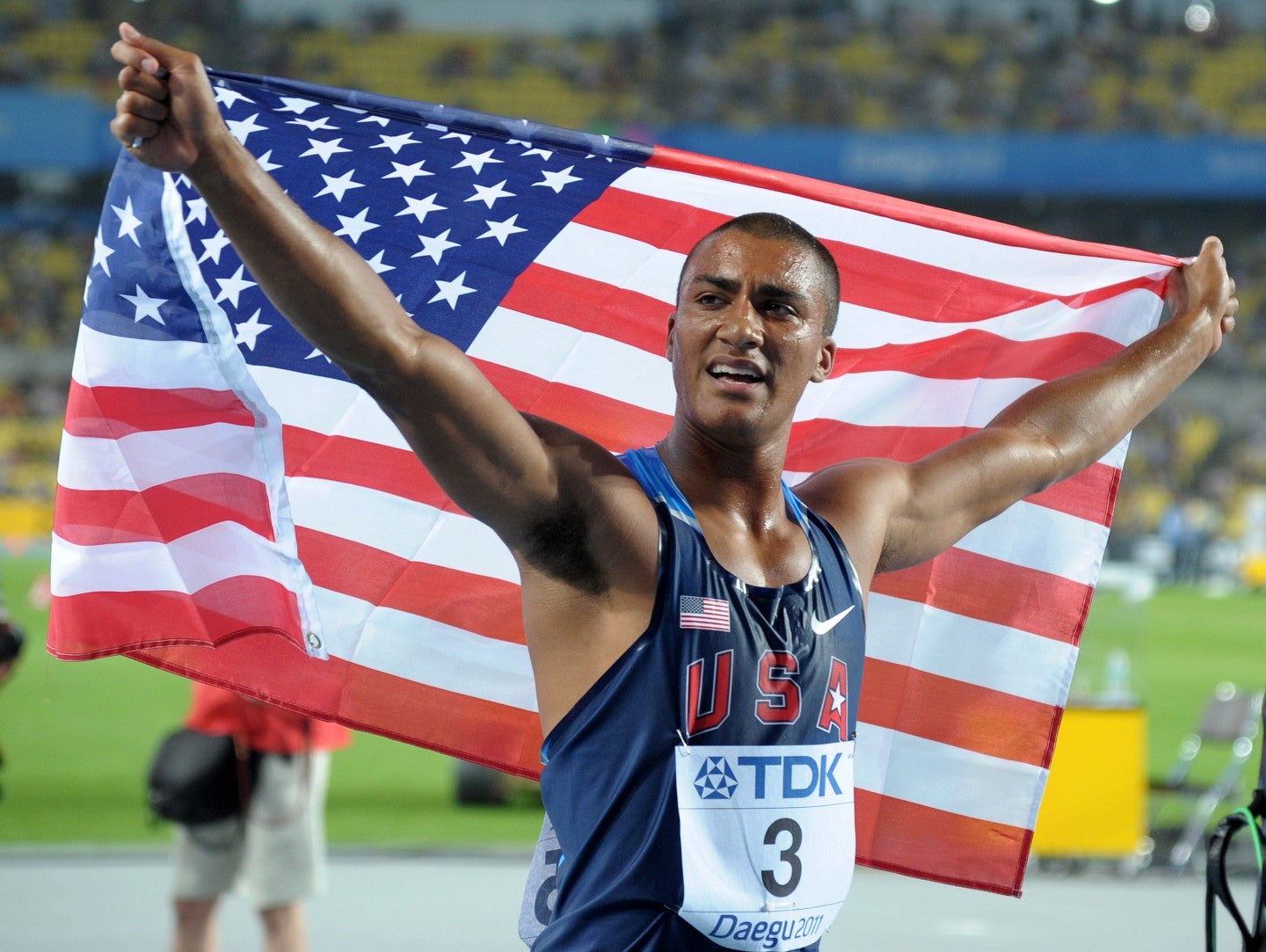 Ashton Eaton holds an American Flag in the air