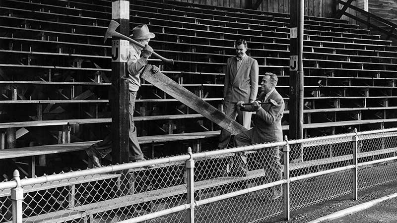 Three men, including University of Oregon athletic director Leo Harris (holding the sledge hammer) posing for a commemorative shot as work to remove the north bleachers at Hayward Field is set to begin in 1950. Three men, including University of Oregon athletic director Leo Harris (holding the sledge hammer) posing for a commemorative shot as work to remove the north bleachers at Hayward Field is set to begin in 1950.