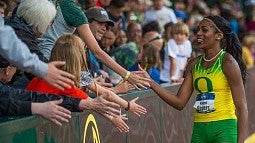 Raevyn Rogers getting high-fives from fans on a victory lap at Hayward Field